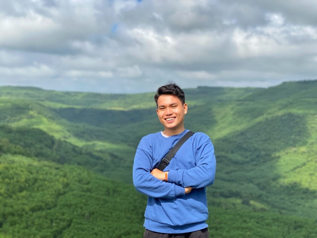 A young man enjoys the vibrant landscape of Tuy Hòa, Vietnam, radiating happiness.